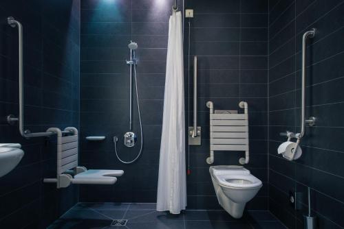 a bathroom with a shower and a toilet in it at Vienna House by Wyndham Andel's Berlin in Berlin
