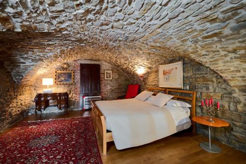 una camera con letto e parete in pietra di CasaBlanca charme & relax a Bergamo