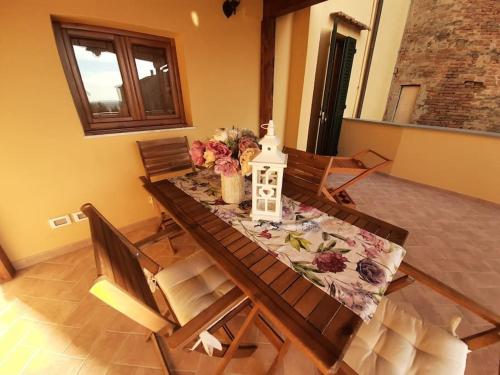a dining room table with flowers on top of it at Lajatico Rentals - Terrazza sul Tramonto del Silenzio in Laiatico