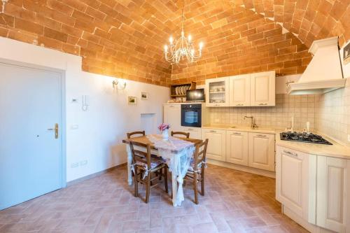a kitchen with a table and chairs in a room at Lajatico Rentals - Terrazza sul Tramonto del Silenzio in Laiatico