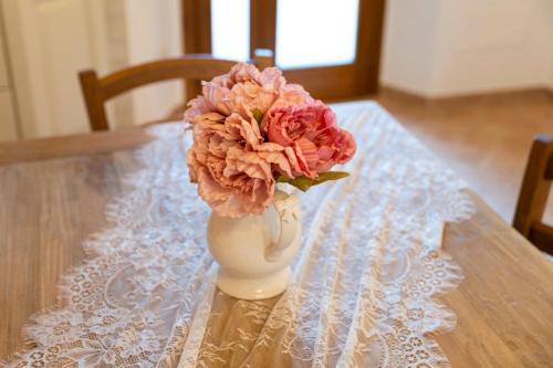 a vase filled with pink flowers sitting on a table at Lajatico Rentals - Terrazza sul Tramonto del Silenzio in Laiatico
