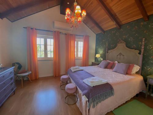 a bedroom with a bed and a chandelier at Villa Silene in Covilhã