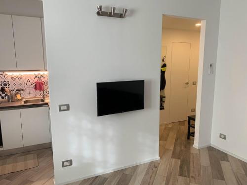 ein Wohnzimmer mit einer weißen Wand und einem TV darauf in der Unterkunft ANDREA in Mailand