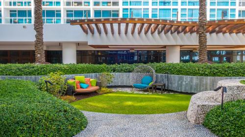 un patio en un edificio con palmeras y sillas en 1 Bedroom Private Residence at Carillon Miami Resort -911, en Miami Beach