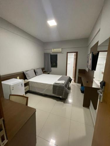 a bedroom with a bed and a desk in it at Maper Ouro in Parauapebas