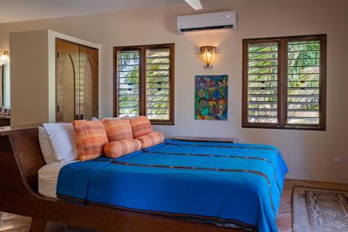 - une chambre avec un lit bleu et un canapé dans l'établissement La Perla del Caribe - Villa Pearl, à San Pedro