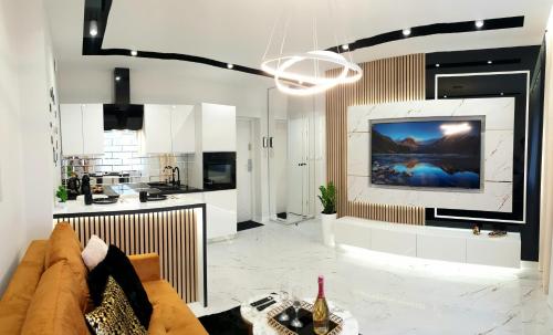 uma sala de estar com um sofá e uma televisão na parede em VIP Room 2+2 em Konin