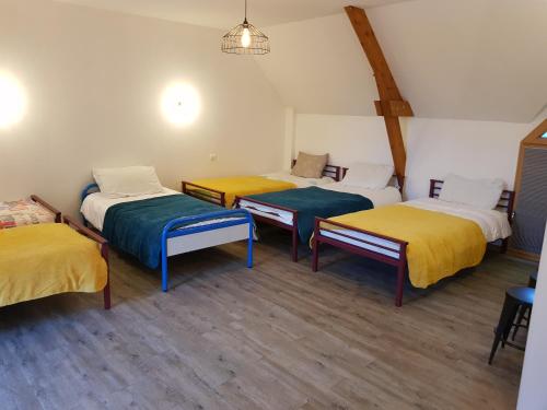 Cette chambre comprend 4 lits avec des draps jaunes et bleus. dans l'établissement Magnifique villa avec piscine intérieure, à Saint-Pois