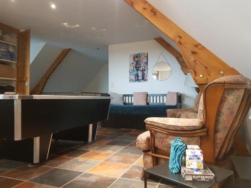 a living room with a piano and a couch at Magnifique villa avec piscine intérieure in Saint-Pois
