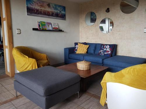 a living room with a blue couch and a table at Magnifique villa avec piscine intérieure in Saint-Pois