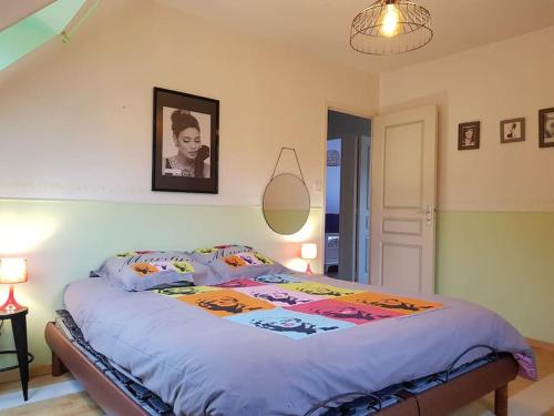 a bed in a bedroom with a picture on the wall at Magnifique villa avec piscine intérieure in Saint-Pois