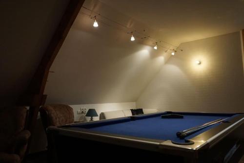 a pool table in a living room with lights at Magnifique villa avec piscine intérieure in Saint-Pois