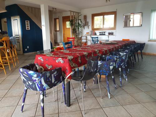 a long table with red and blue tables and chairs at Magnifique villa avec piscine intérieure in Saint-Pois
