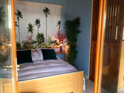 a bedroom with a bed with palm trees on the wall at Maison d'une chambre avec jardin et wifi a Lectoure a 4 km de la plage in Lectoure