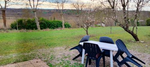 a white table and two chairs with a field at Maison d'une chambre avec jardin et wifi a Lectoure a 4 km de la plage in Lectoure