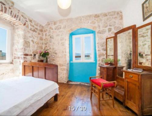 a bedroom with a bed and a blue door at Holiday Home Bogumila in Risan