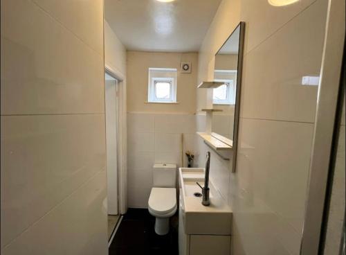 a bathroom with a toilet and a sink and a mirror at En-suite near everything. Shepherd's Bush - London in London