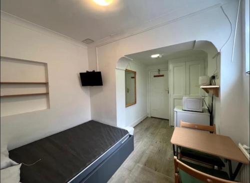 a room with a bed and a table in it at En-suite near everything. Shepherd's Bush - London in London