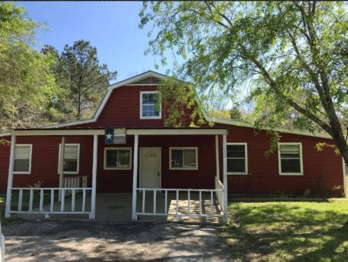 a red house with a white porch at Pure Country, plenty of space & trees, relaxing! in Lumberton