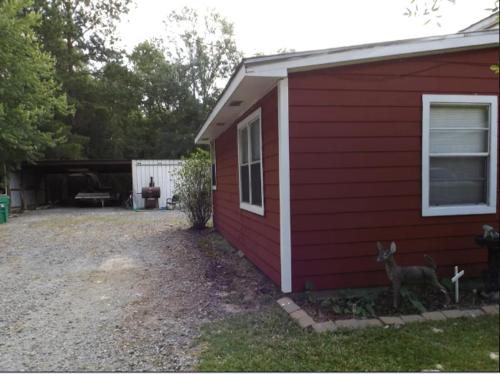 a red house with a deer in front of it at Pure Country, plenty of space & trees, relaxing! in Lumberton