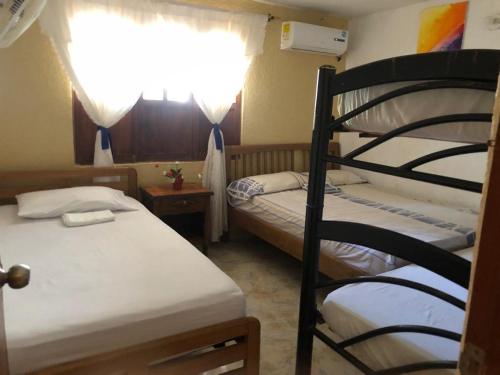 1 dormitorio con 2 literas y ventana en Alojamiento Casa Taganga en Taganga