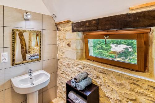 baño con lavabo y ventana en Gites de Ponsillou, en Lavercantière