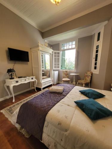 um quarto com uma cama grande e uma secretária em Casa Villa Constanza em Itaipava