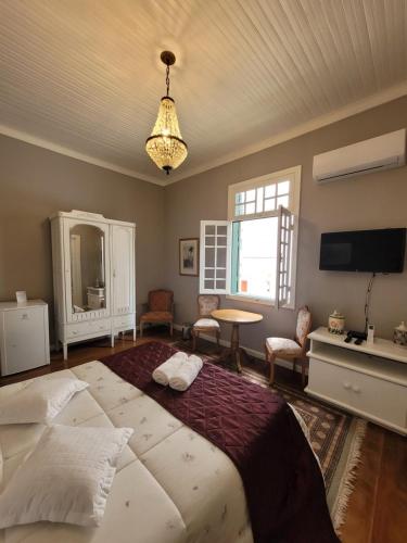 a bedroom with a large bed and a tv at Casa Villa Constanza in Itaipava
