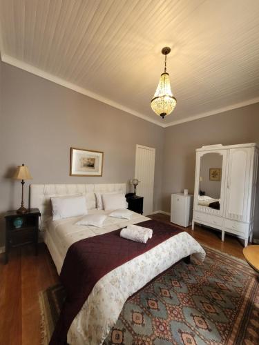 um quarto com uma cama grande e um lustre em Casa Villa Constanza em Itaipava