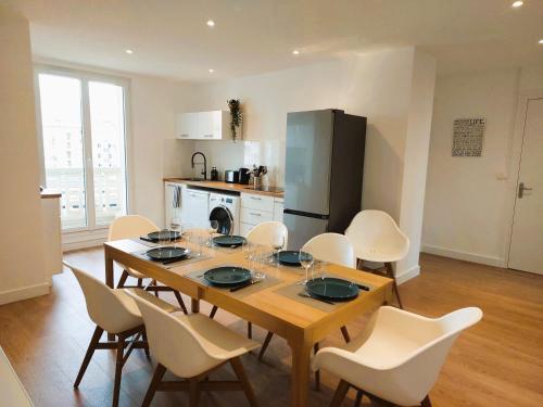 a dining room with a table and chairs and a kitchen at Champon - Lumineux 2 Chambres avec Garage privé - Tram à 1 min in Grenoble