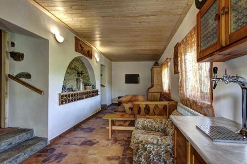 un soggiorno con soffitti in legno, tavolo e sedie. di Šumavská Chata a Volary