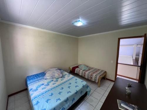 a small bedroom with a bed and a table at Aconchego em Teresópolis com piscina privativa próximo a feirinha in Teresópolis