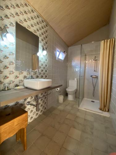 a bathroom with a sink and a shower and a toilet at Villa Silene in Covilhã