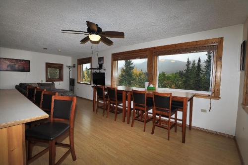 a dining room and living room with a table and chairs at Denali Park View House in Healy