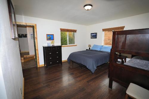 a bedroom with a bed and a dresser at Denali Park View House in Healy