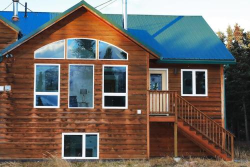a log cabin with a staircase and windows at 3 Bedroom Home with Amazing Views 11 mi from Denali in Healy