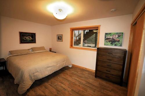 1 dormitorio con cama, ventana y vestidor en 3 Bedroom Home with Amazing Views 11 mi from Denali en Healy