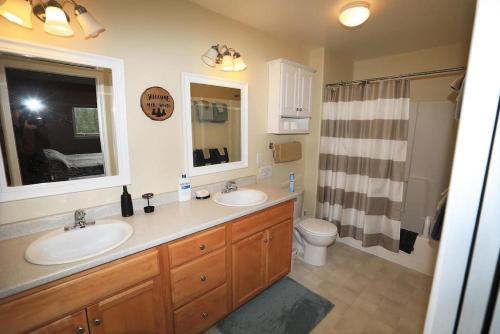 baño con 2 lavabos, aseo y ventana en 5 Star Denali Park Spacious Family Home, en Healy