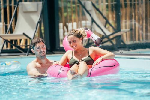 un homme et une femme assis dans une piscine dans l'établissement Holiday Inn - Bordeaux-Merignac, an IHG Hotel, à Mérignac