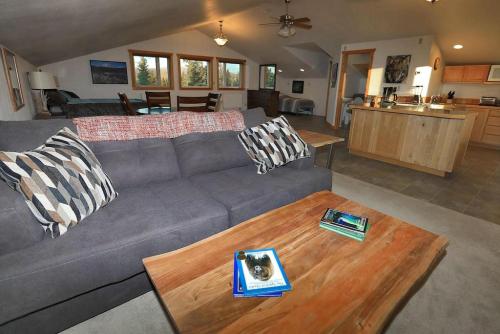 a living room with a gray couch and a wooden table at Denali King Suite with Amazing Views in Healy