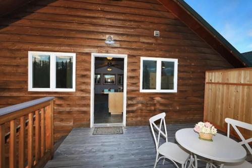 a wooden cabin with a table and chairs on a deck at Denali King Suite with Amazing Views in Healy