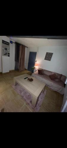 sala de estar con mesa de centro y cama en Appartement cosy à 5mn de la gare de denain., en Denain