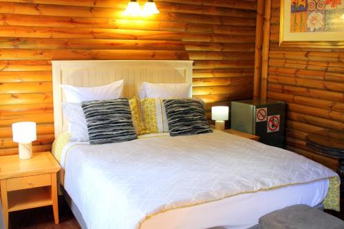 sypialnia z łóżkiem w drewnianym domku w obiekcie Ndlovu Log Home Dinokeng w mieście Klipdrift
