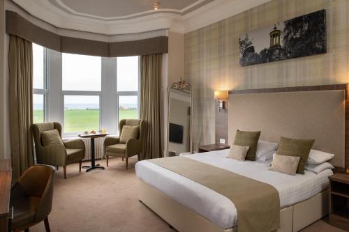 una camera d'albergo con letto, tavolo e sedie di Fairfield House Hotel ad Ayr