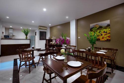 ein Esszimmer mit Tischen und Stühlen sowie eine Küche in der Unterkunft My Linh Hotel in Hanoi
