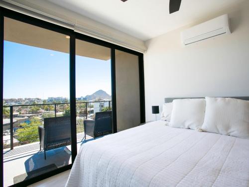 a bedroom with a white bed and a large window at Sea Esta - Terra 194 in Cabo San Lucas