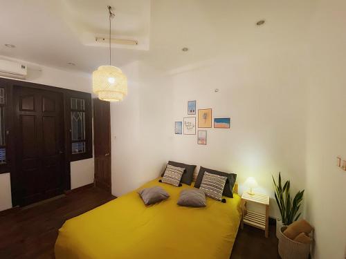 a bedroom with a large yellow bed in a room at Michi House Giang Văn Minh đối diện Bảo tàng HCM in Hanoi