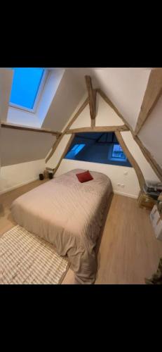 ein Schlafzimmer mit einem Bett in einem Zimmer mit einem Fenster in der Unterkunft Maison de ville in Coulombs