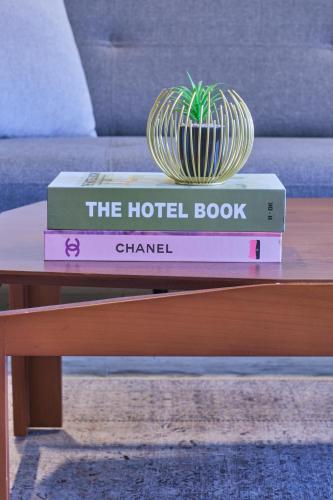 two books on a coffee table with a plant on top at Maison 7 in El Obour