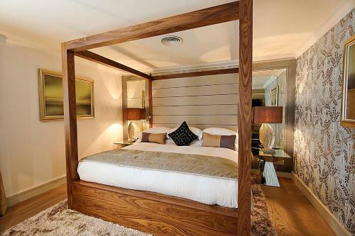 a bedroom with a canopy bed in a room at Grosvenor Pulford Hotel & Spa in Pulford